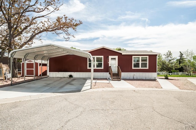 999 Fortino Blvd Unit 237, Pueblo, CO 81008 - manufactured / mobile home featuring a detached carport, entry steps, a storage unit, driveway, and fence
