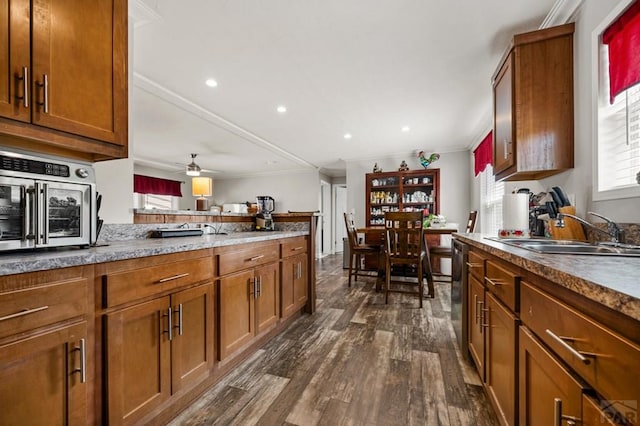 999 Fortino Blvd Unit 237, Pueblo, CO 81008 - kitchen with a sink, dark wood-type flooring, brown cabinetry, crown molding, and ceiling fan