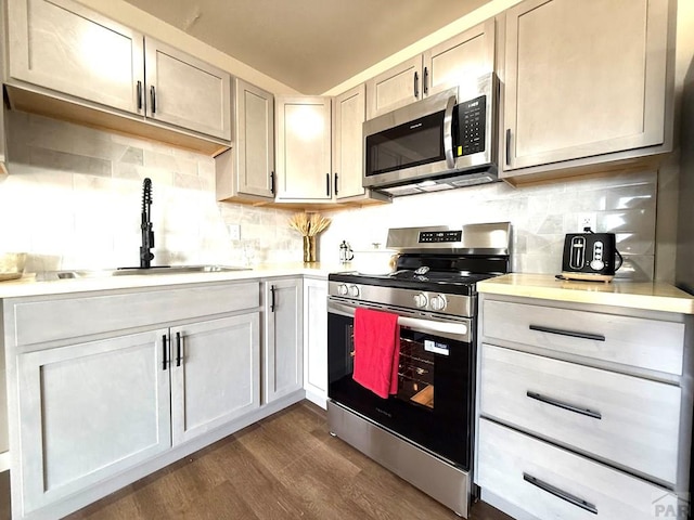 326 W Golden Eagle Way Unit 328, Pueblo West, CO 81007 - kitchen featuring appliances with stainless steel finishes, light countertops, dark wood-style floors, and decorative backsplash