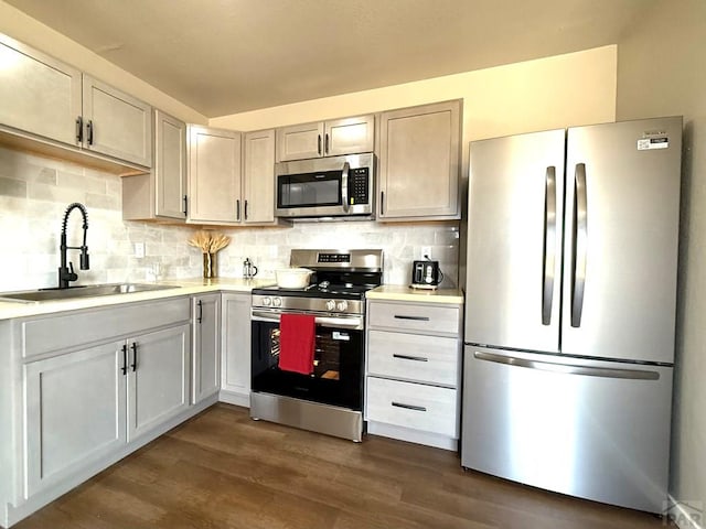 326 W Golden Eagle Way Unit 328, Pueblo West, CO 81007 - kitchen featuring stainless steel appliances, a sink, light countertops, dark wood finished floors, and backsplash