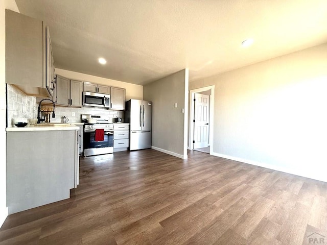 326 W Golden Eagle Way Unit 328, Pueblo West, CO 81007 - kitchen featuring stainless steel appliances, light countertops, dark wood-type flooring, decorative backsplash, and gray cabinetry