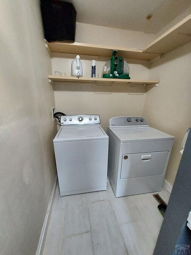 laundry room with laundry area, baseboards, and separate washer and dryer