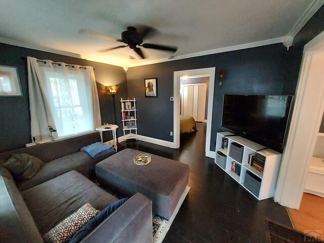 living room featuring ornamental molding, baseboards, and a ceiling fan