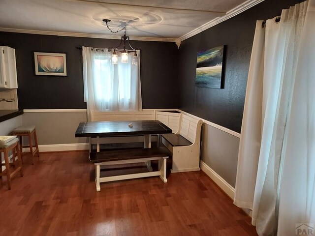 dining space with ornamental molding, baseboards, and wood finished floors