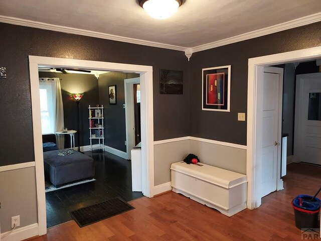 hall with baseboards, wood finished floors, and crown molding