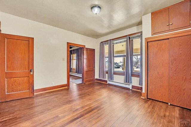 interior space with light wood finished floors, baseboard heating, and baseboards