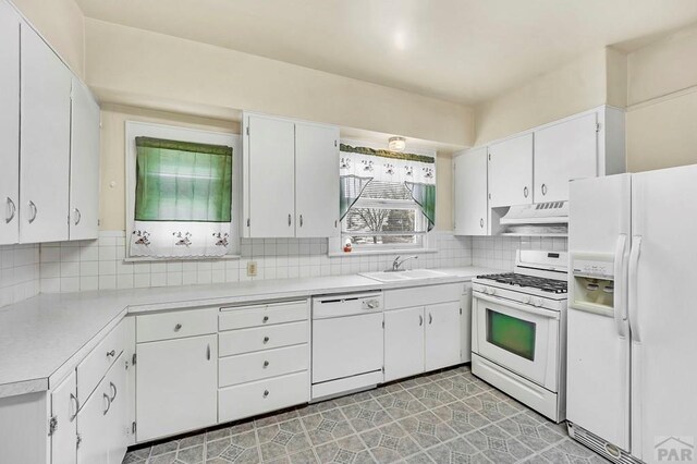 kitchen featuring light countertops, white appliances, white cabinetry, and under cabinet range hood