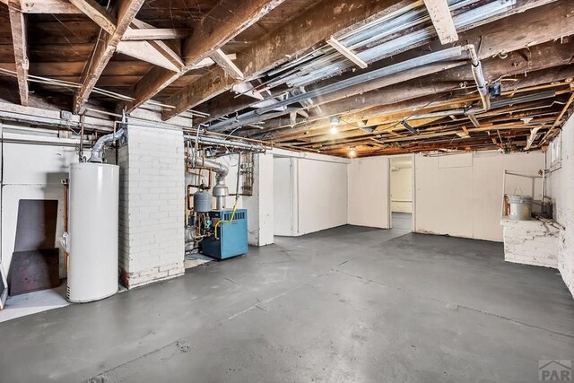 unfinished basement with gas water heater and a heating unit