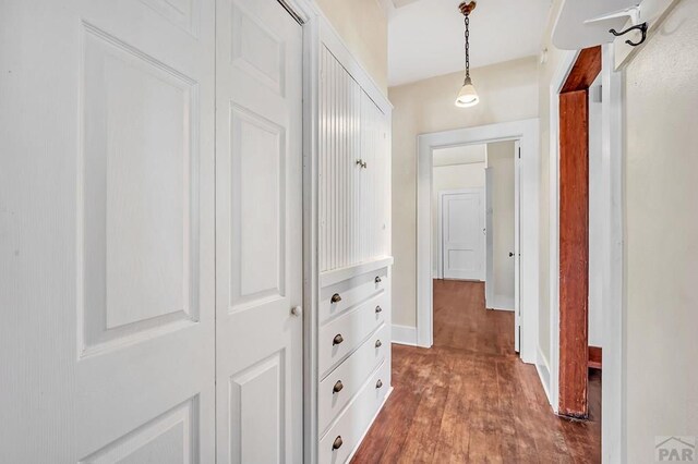 hallway with dark wood-style flooring and baseboards