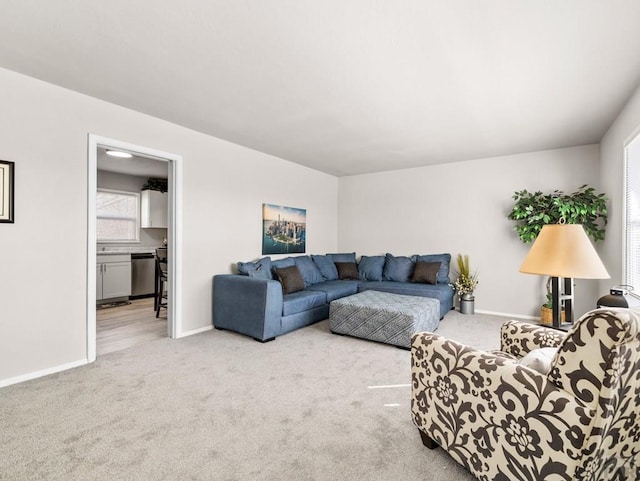 carpeted living area with baseboards