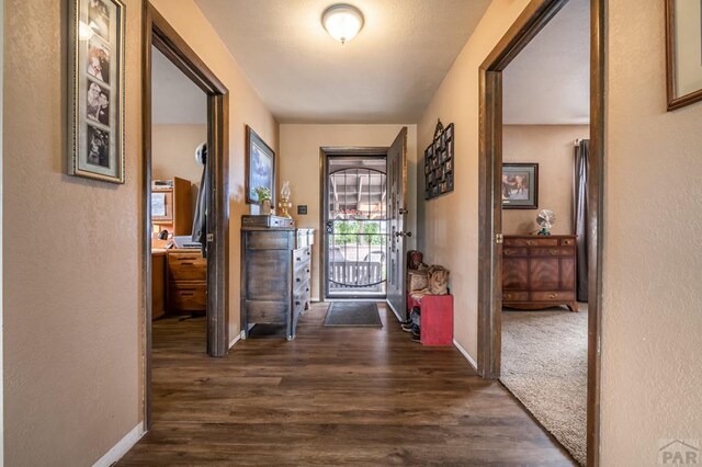 hall with baseboards and dark wood finished floors