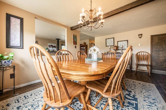 dining space featuring dark wood-type flooring, baseboards, and an inviting chandelier