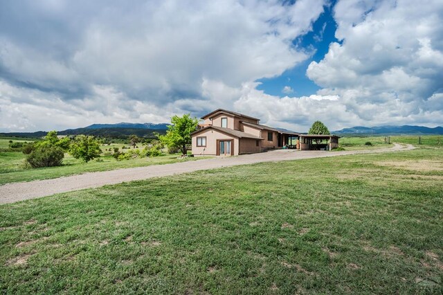 exterior space featuring an attached carport, a rural view, and a mountain view