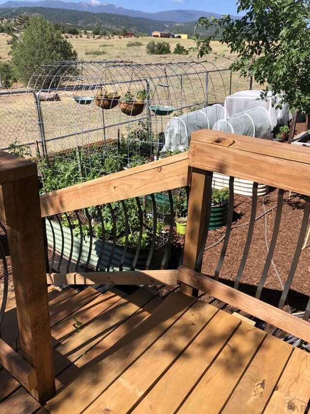 deck featuring a rural view, a vegetable garden, and a mountain view