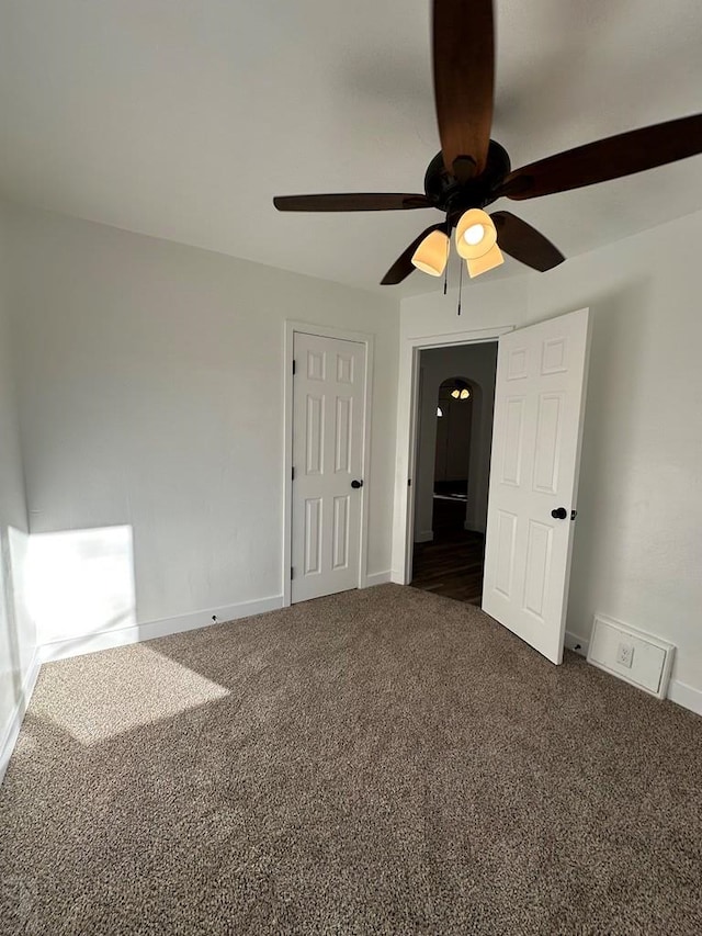 empty room with dark carpet and baseboards