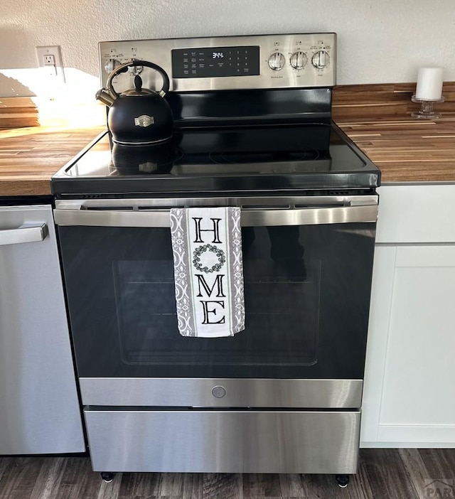 details with dark wood-style floors, white cabinets, and stainless steel range with electric cooktop