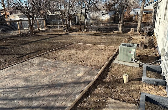 view of yard with central AC unit and fence