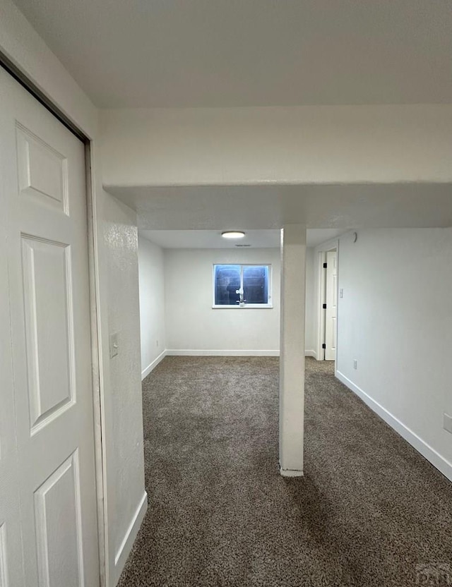 finished basement featuring dark carpet and baseboards