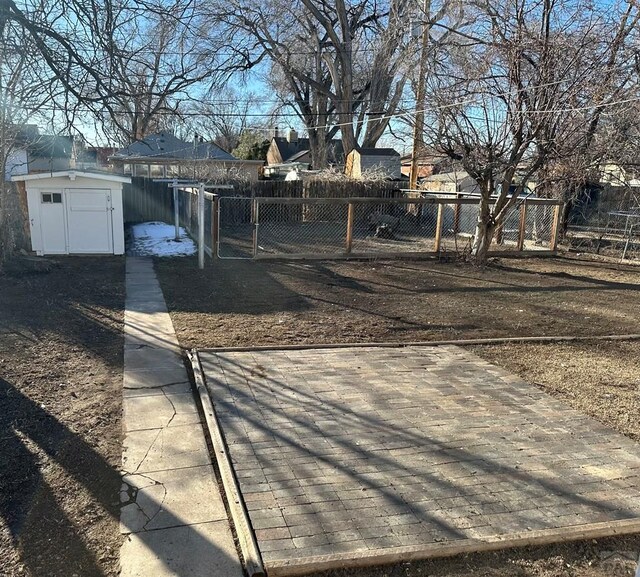 view of yard featuring a storage shed, an outdoor structure, and fence private yard