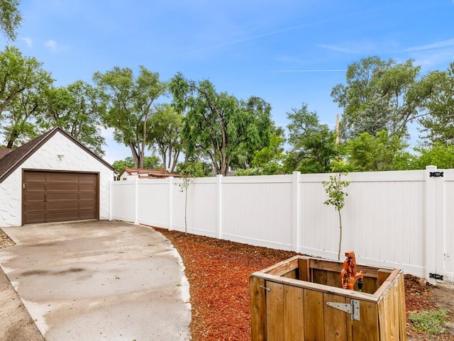 view of yard with concrete driveway and an outdoor structure