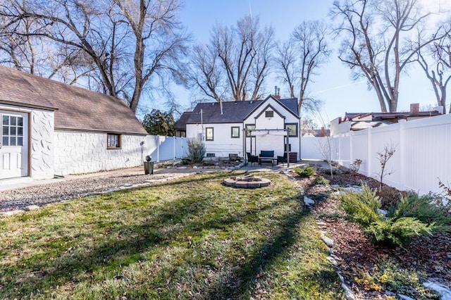 view of yard featuring a patio area, a fenced backyard, and a fire pit