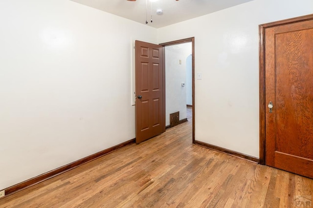 unfurnished bedroom with light wood finished floors, a ceiling fan, and baseboards