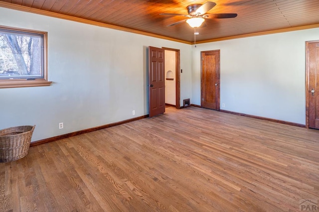 spare room featuring wooden ceiling, baseboards, crown molding, and light wood finished floors