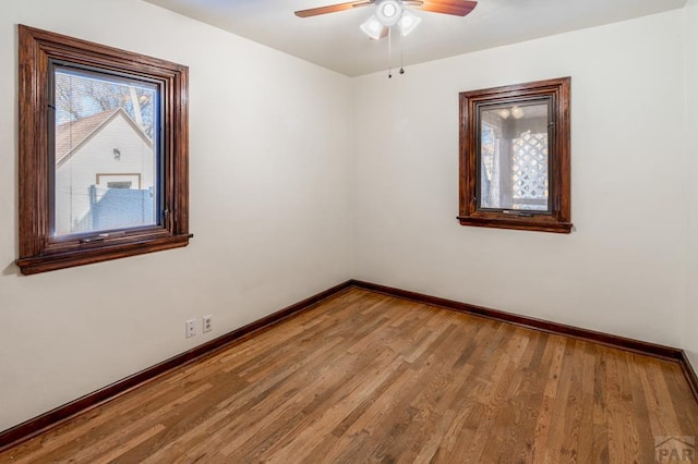 unfurnished room featuring ceiling fan, baseboards, and wood finished floors