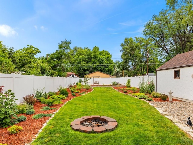 view of yard featuring a fire pit and a fenced backyard