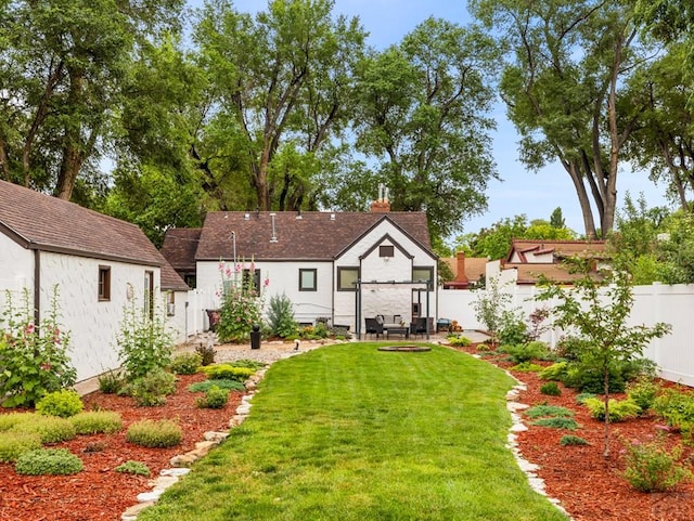 back of property featuring a fenced backyard and a lawn