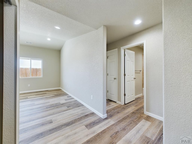 151 S Stardust Cir, Pueblo West, CO 81007 - empty room with a textured ceiling, visible vents, wood finished floors, a textured wall, and baseboards