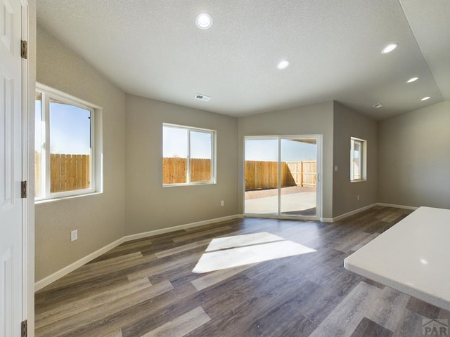 151 S Stardust Cir, Pueblo West, CO 81007 - unfurnished living room featuring dark wood-style flooring, baseboards, recessed lighting, and a textured ceiling