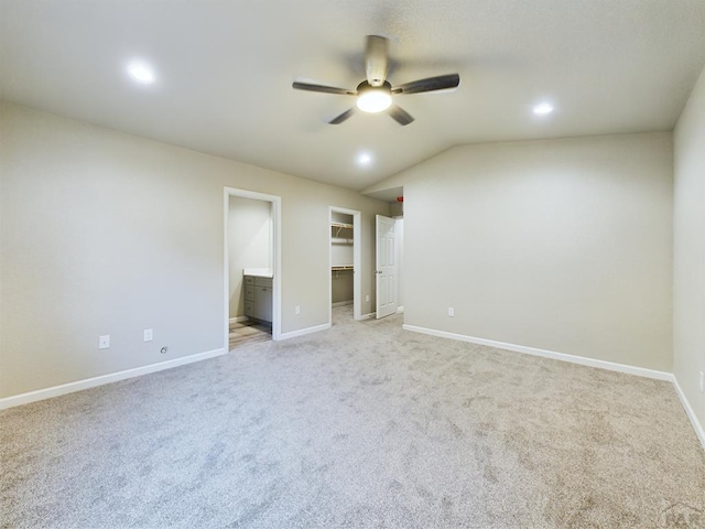 151 S Stardust Cir, Pueblo West, CO 81007 - unfurnished bedroom featuring baseboards, vaulted ceiling, recessed lighting, a walk in closet, and light colored carpet