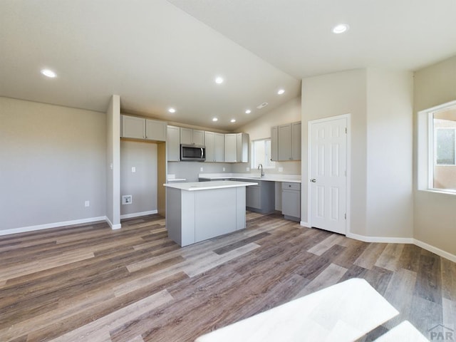 151 S Stardust Cir, Pueblo West, CO 81007 - kitchen with stainless steel microwave, light wood-style flooring, a healthy amount of sunlight, and a kitchen island