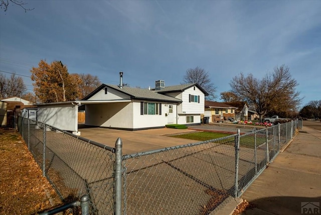 tri-level home featuring fence and stucco siding