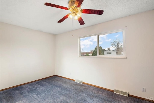 carpeted empty room featuring a ceiling fan, visible vents, and baseboards