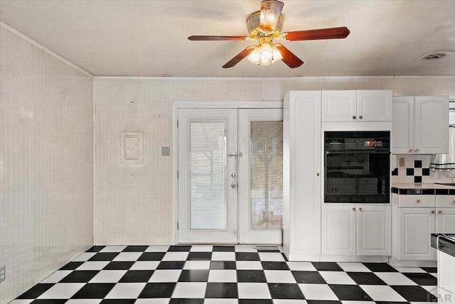 kitchen featuring tile counters, dark floors, oven, french doors, and white cabinetry