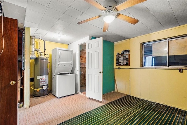 clothes washing area featuring laundry area, light colored carpet, gas water heater, and stacked washer and clothes dryer