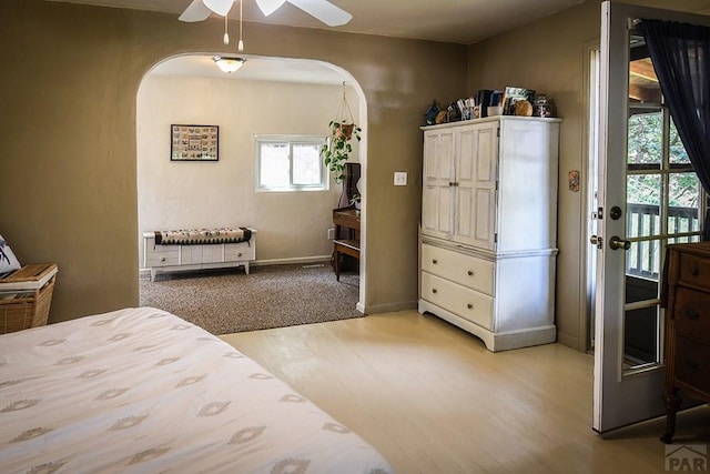 8570 Pine Dr, Beulah, CO 81023 - bedroom featuring arched walkways, light wood-type flooring, and a ceiling fan