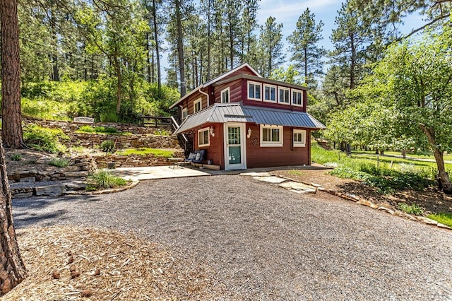 8570 Pine Dr, Beulah, CO 81023 - view of front of house with a metal roof, a patio area, and view of scattered trees