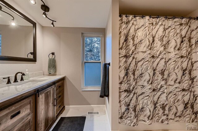 full bath with a shower with curtain, baseboards, visible vents, and vanity