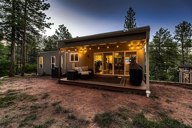 rear view of house with central AC unit and a wooden deck