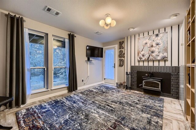 living area with visible vents, a textured ceiling, baseboards, and wood finished floors