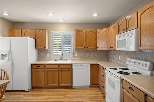 4317 Outlook Blvd Unit D, Pueblo, CO 81008 - kitchen with white appliances, a sink, tasteful backsplash, light countertops, and light wood-style flooring