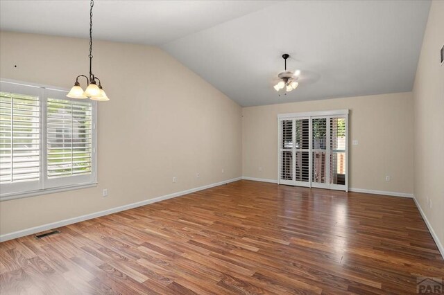 4317 Outlook Blvd Unit D, Pueblo, CO 81008 - empty room with a chandelier, vaulted ceiling, wood finished floors, baseboards, and ceiling fan