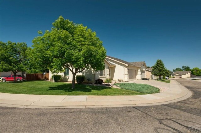 4317 Outlook Blvd Unit D, Pueblo, CO 81008 - obstructed view of property with concrete driveway, a garage, and stucco siding