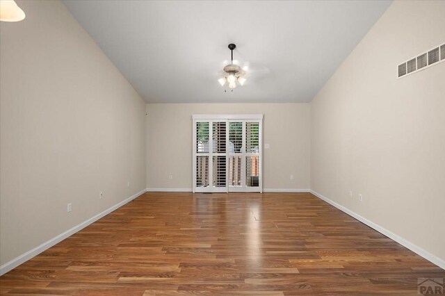4317 Outlook Blvd Unit D, Pueblo, CO 81008 - spare room with wood finished floors, baseboards, and vaulted ceiling