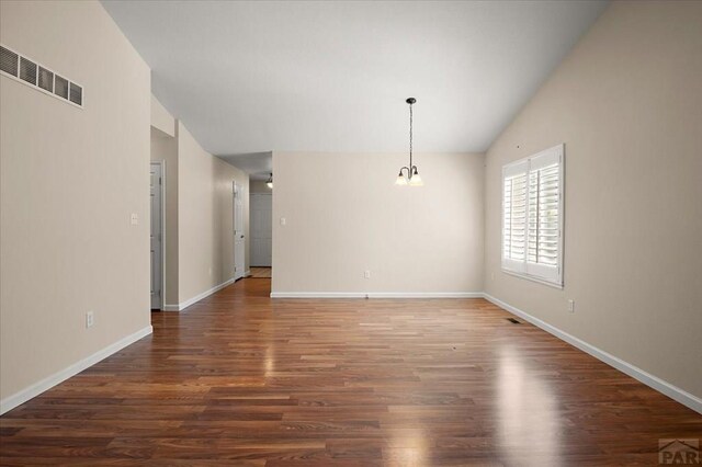 4317 Outlook Blvd Unit D, Pueblo, CO 81008 - unfurnished dining area with wood finished floors, baseboards, a chandelier, and vaulted ceiling