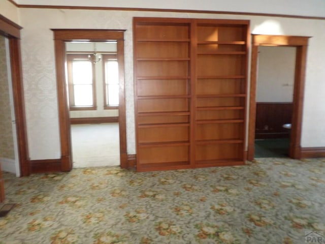 interior space with ornamental molding, carpet, and baseboards