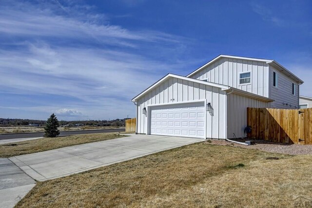 1436 Brewery Rd, Pueblo, CO 81001 - view of side of home featuring fence, an attached garage, driveway, and board and batten siding